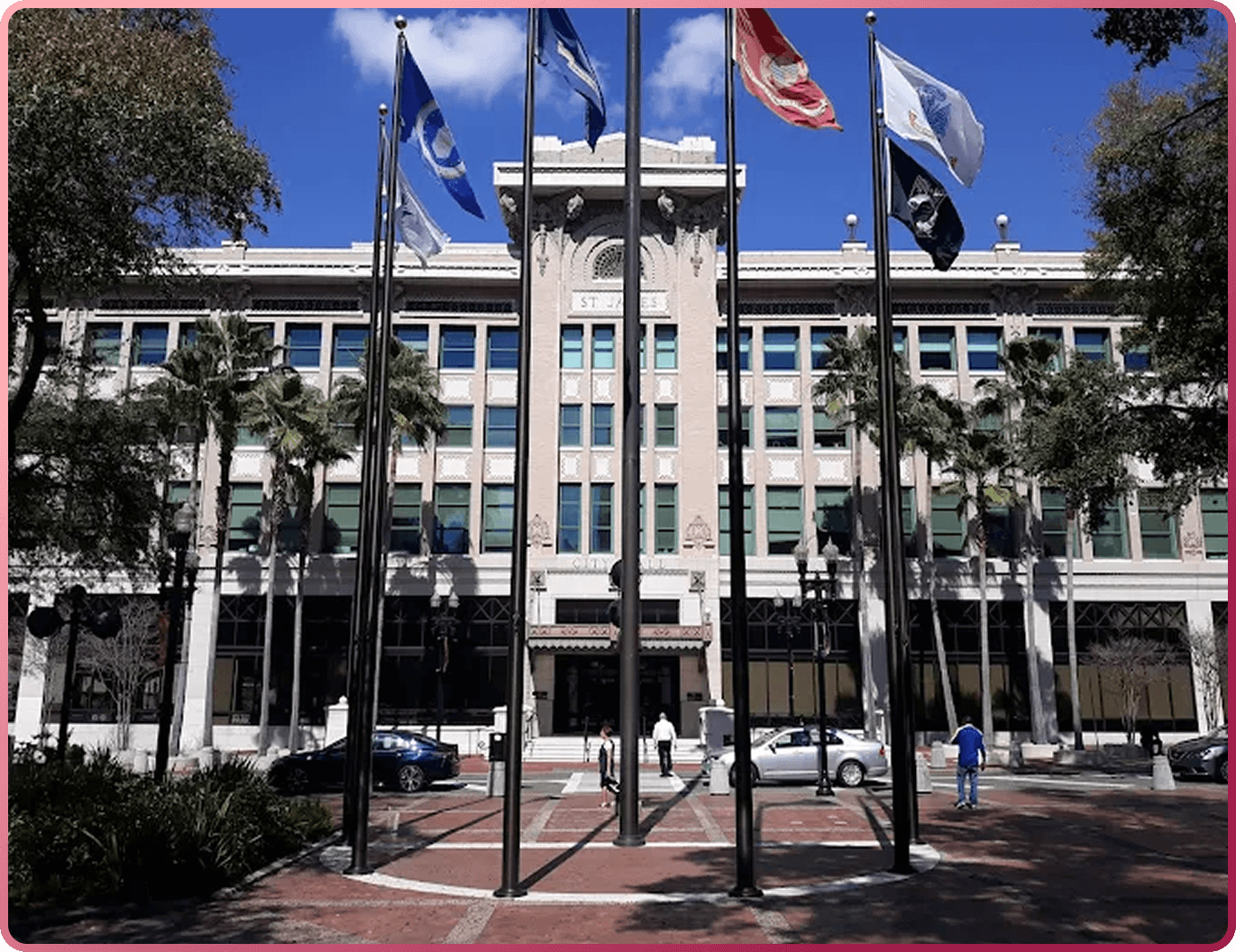 Government building with flags and palm trees out front